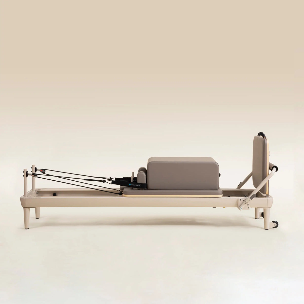 Elina Pilates Nubium Moka Edition Reformer in Seitenansicht mit Sitzbox auf dem Wagen