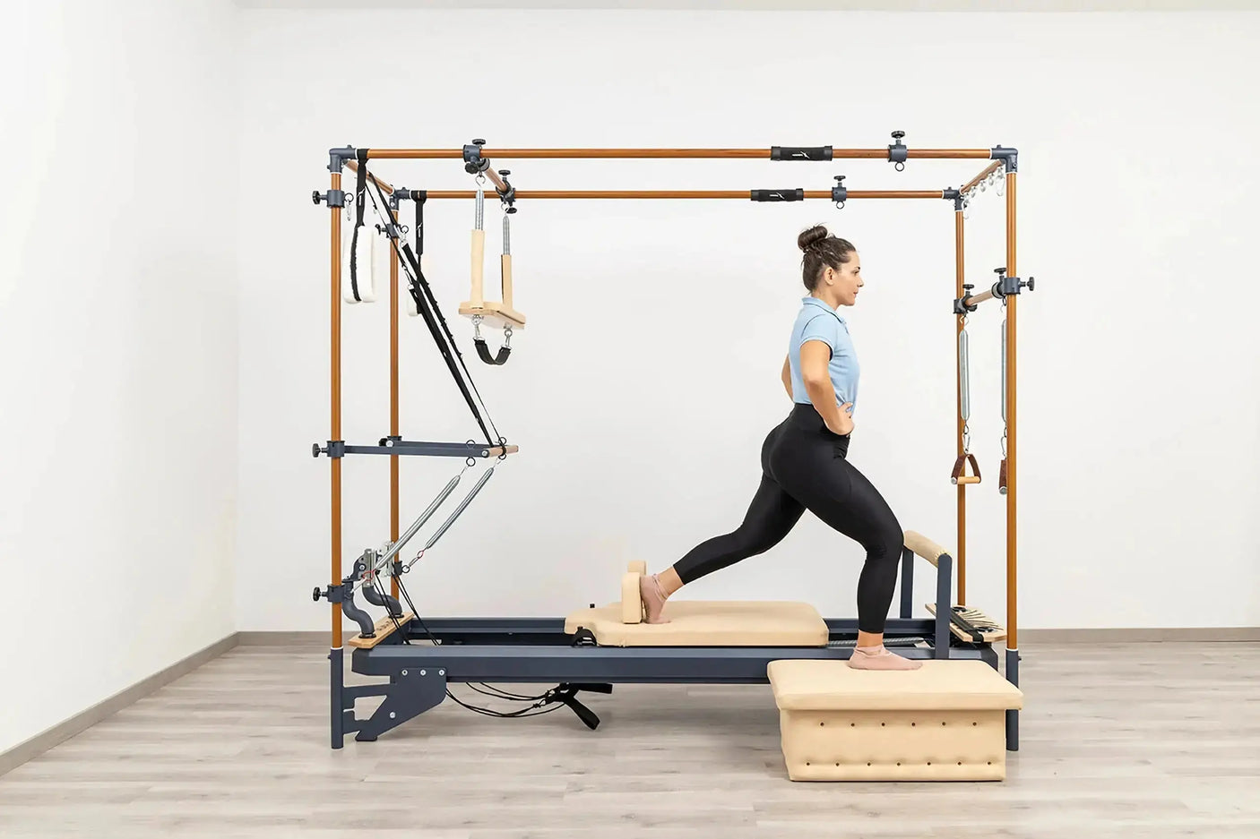 Side view of the HEGREN Cadillac Reformer TALMA 62CR showcasing its steel frame and beige upholstery.