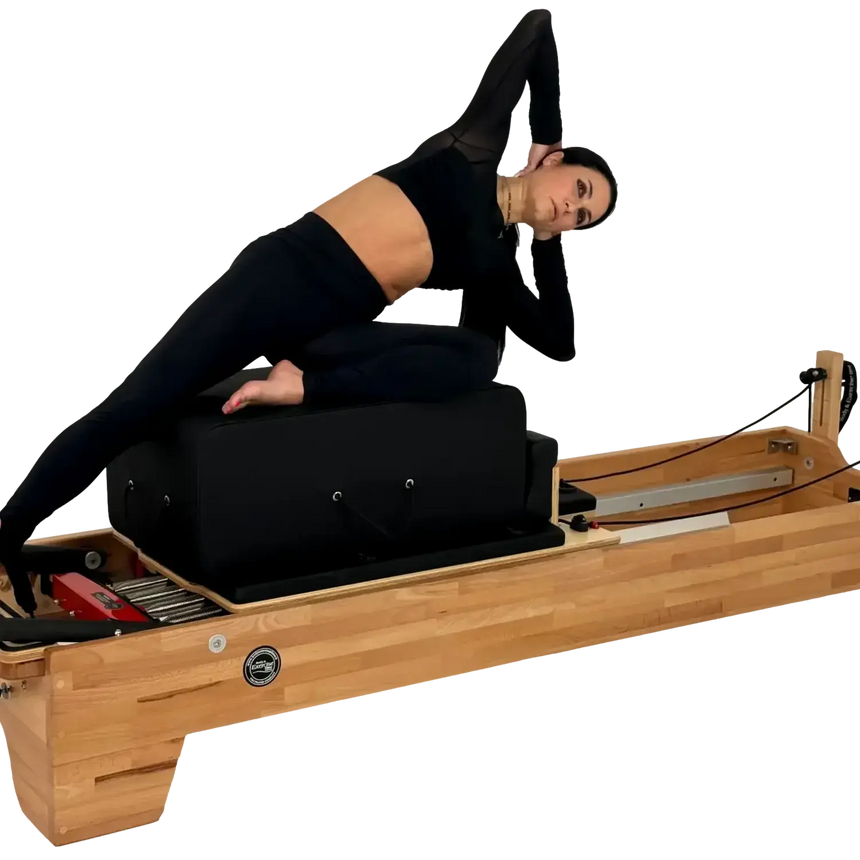 Person using a Pilates reformer machine on a white background