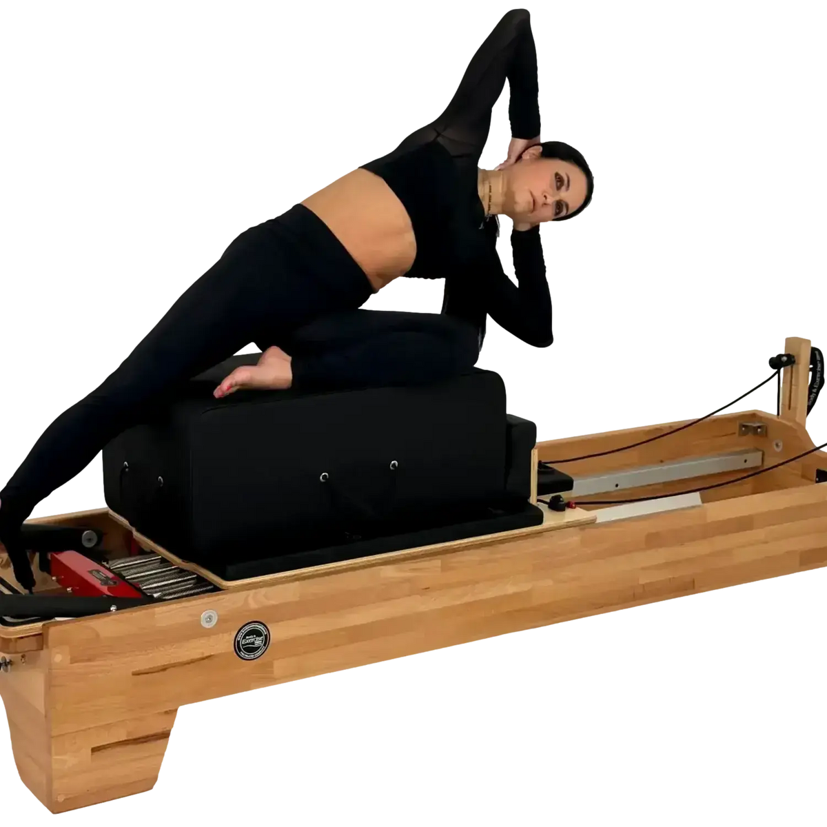 Body & Exercise Reformer Studio P001 aus Buchenholz, Frau bei einer Übung auf dem Reformer, schwarzer Hintergrund
