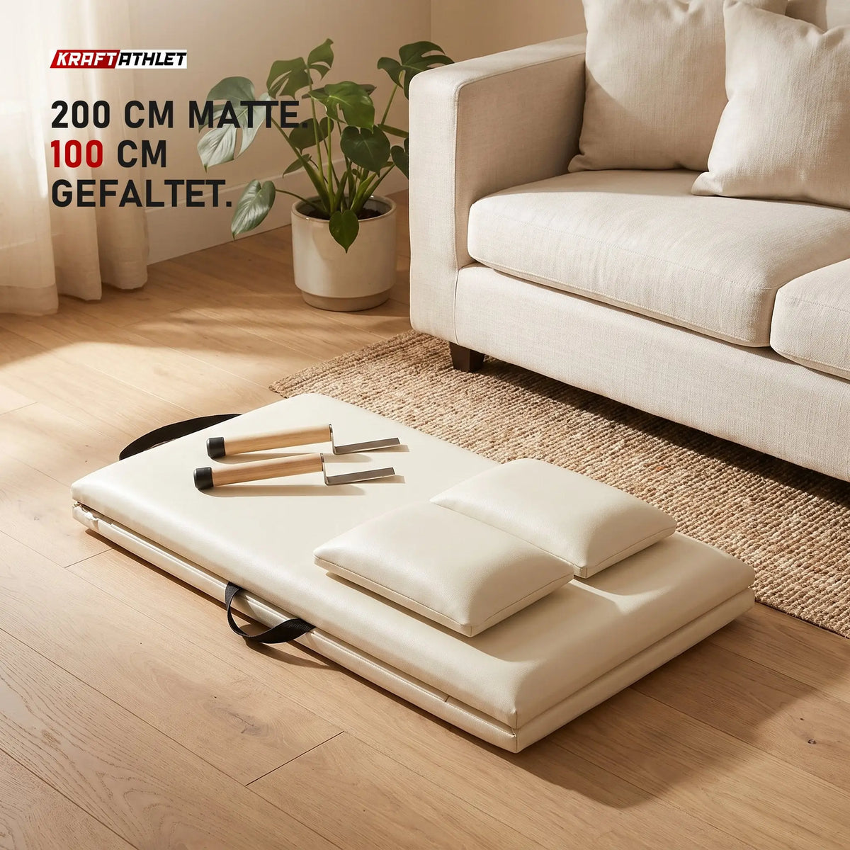Zusammengeklappte Elina Pilates Faltmatte in Elfenbein mit zwei Holzgriffen neben einem Sofa