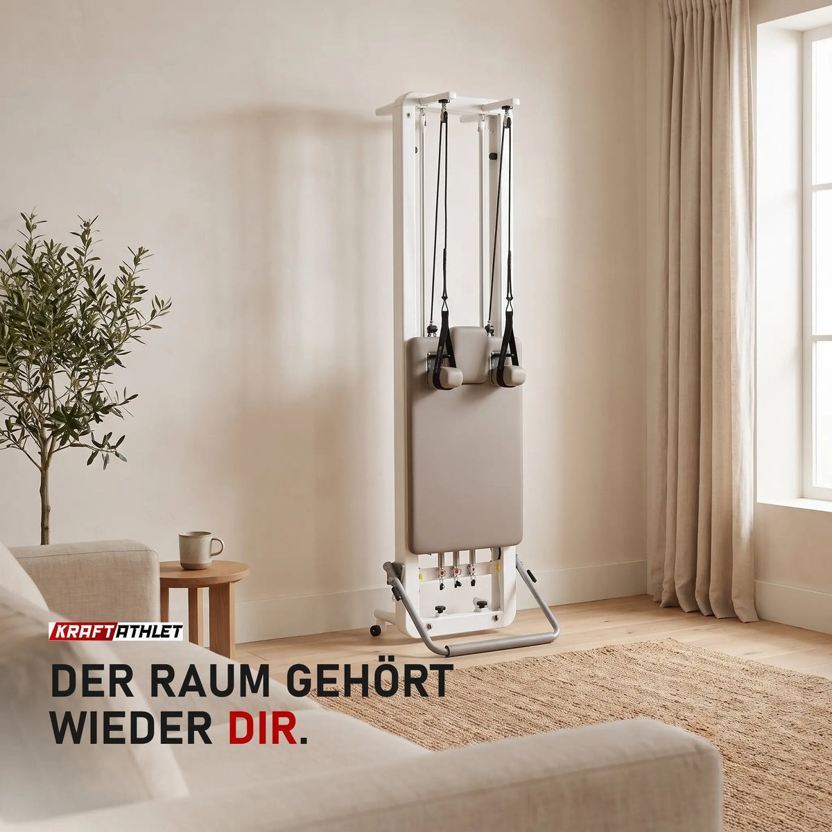 Elina Pilates Nubium Reformer senkrecht an der Wand eines hellen Wohnzimmers, davor freie Fläche