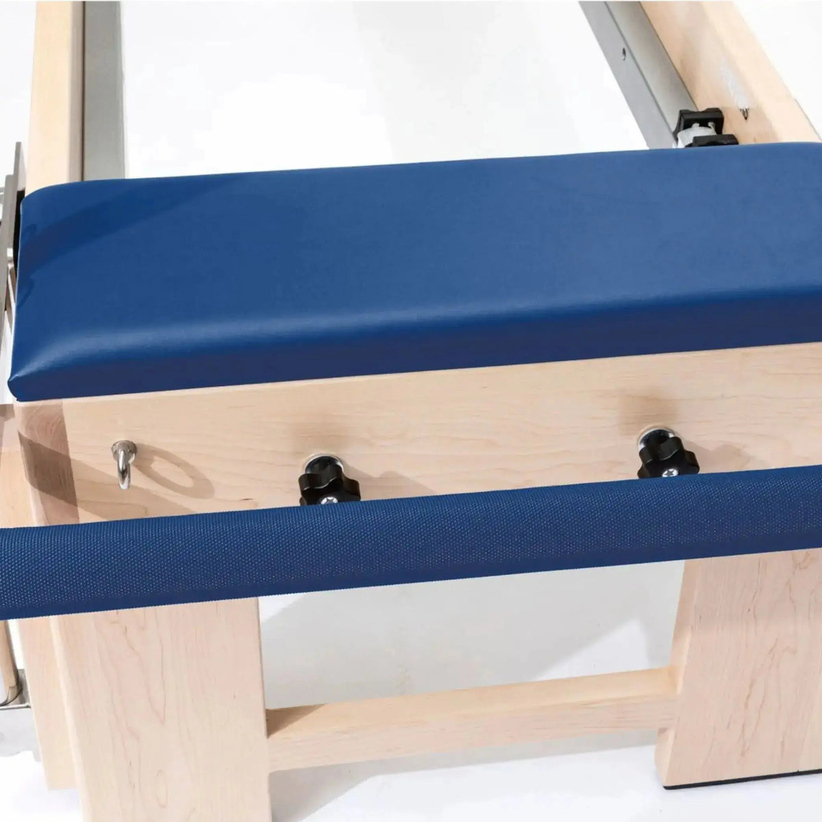 Elina Pilates Cadillac Elite Reformer aus Rock-Ahorn – Detail der Polsterkante mit Verstellknöpfen in Blau