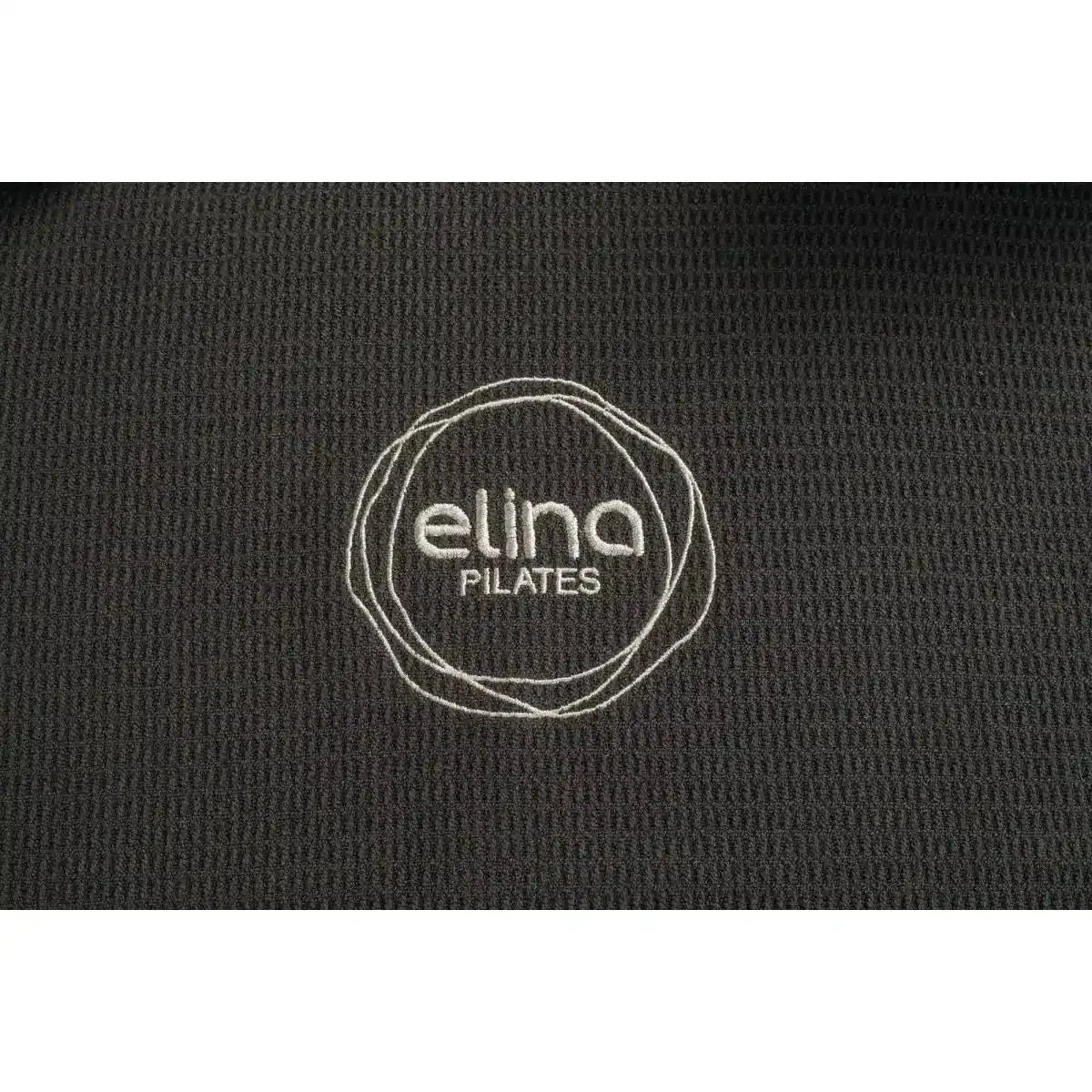 Detail der Oberfläche vom Elina Pilates Machine Towel Reformer-Handtuch mit eingesticktem Elina-Pilates-Logo in Schwarz