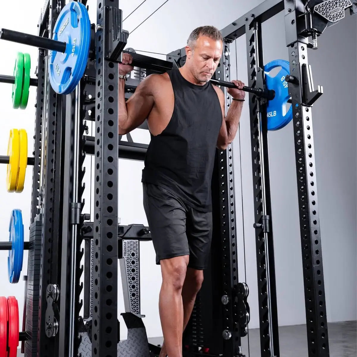 Force USA C20 All-In-One Trainer – Mann mit Langhantel im Rack