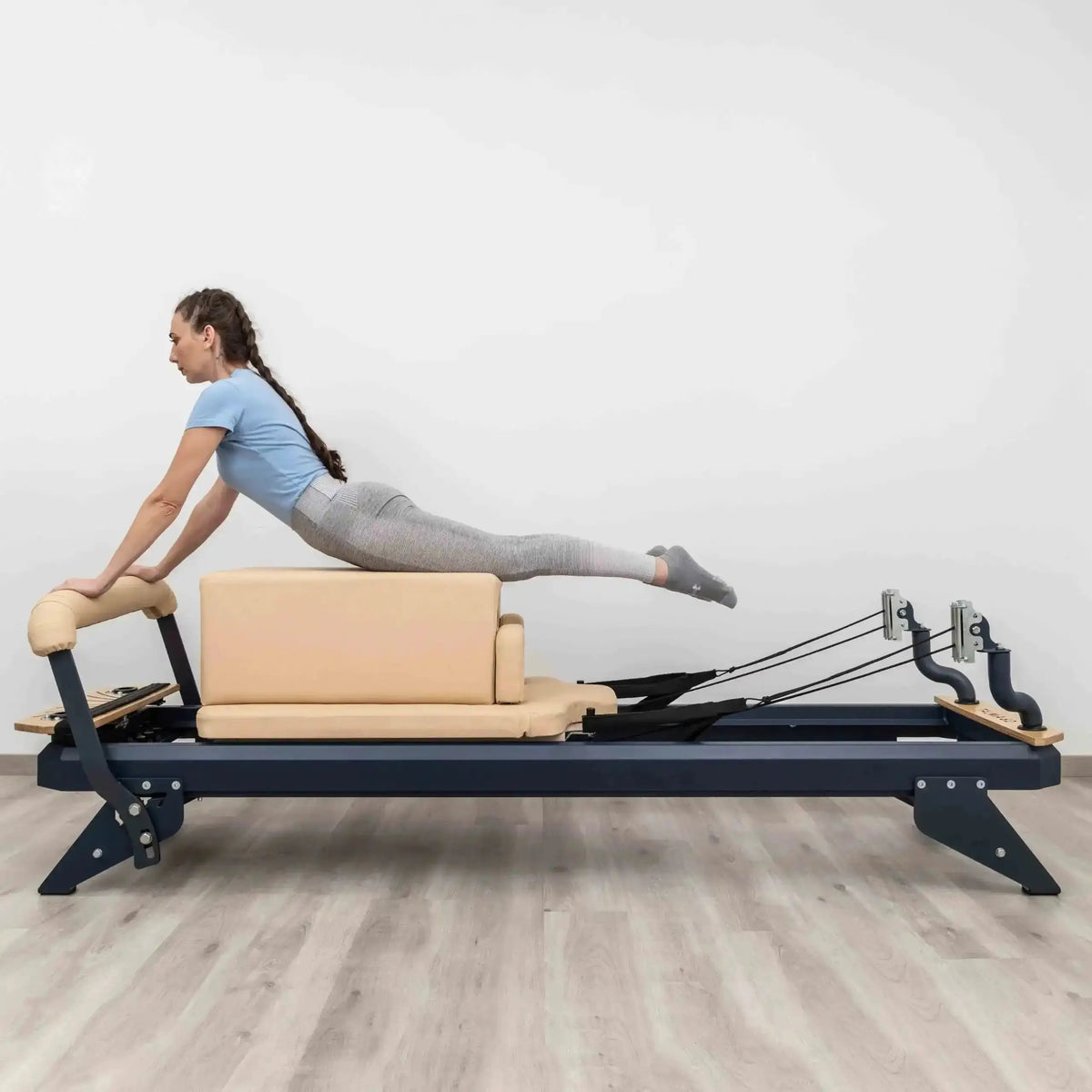 Hegren Pilates Box Modern in Beige, Frau stützt sich beim Training in Bauchlage auf