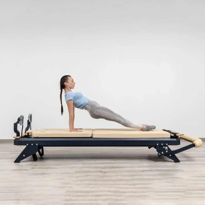 HEGREN Mat Converter TALMA placed on a Pilates Reformer, showcasing its cushioned surface and beige upholstery.