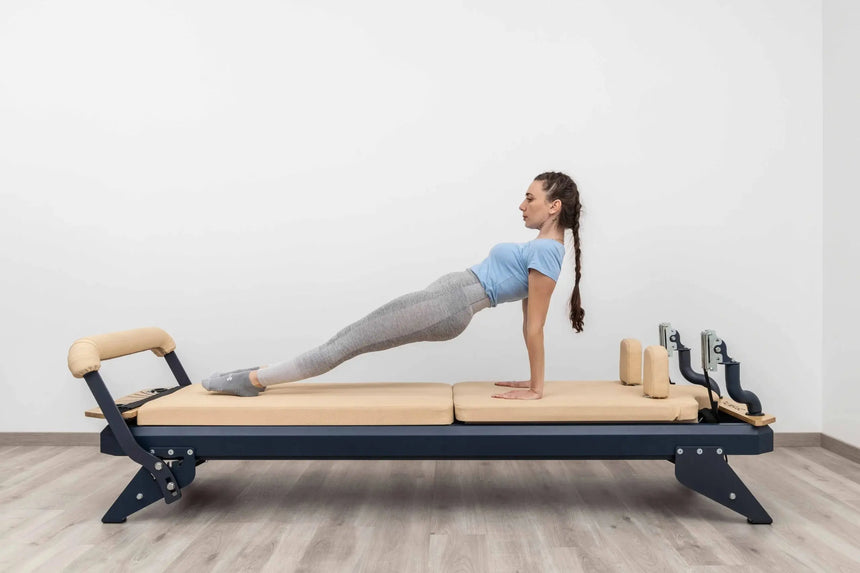 HEGREN Mat Converter TALMA placed on a Pilates Reformer, showcasing its cushioned surface and beige upholstery.