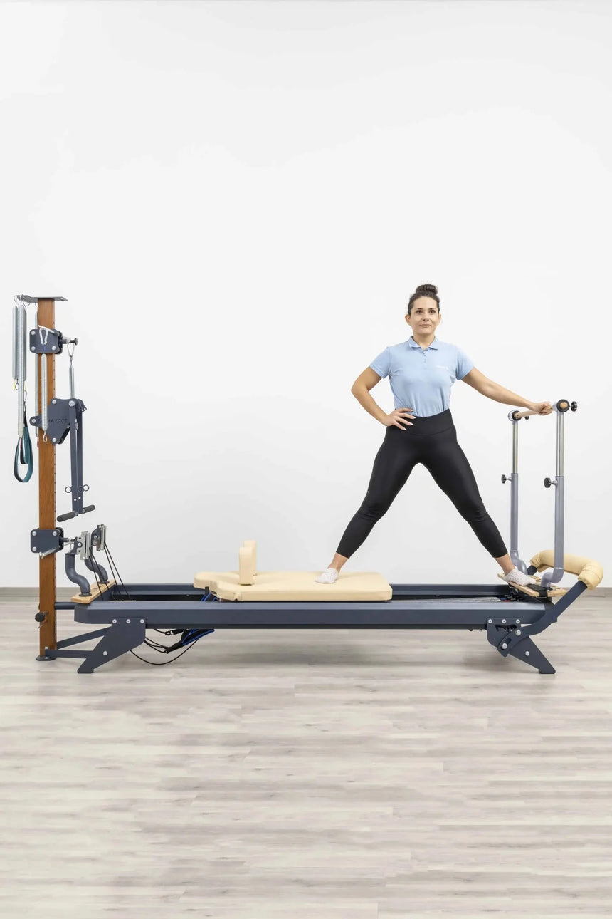 HEGREN Stability Bar attached to a Pilates Reformer, enabling safe execution of standing exercises like side and front splits.