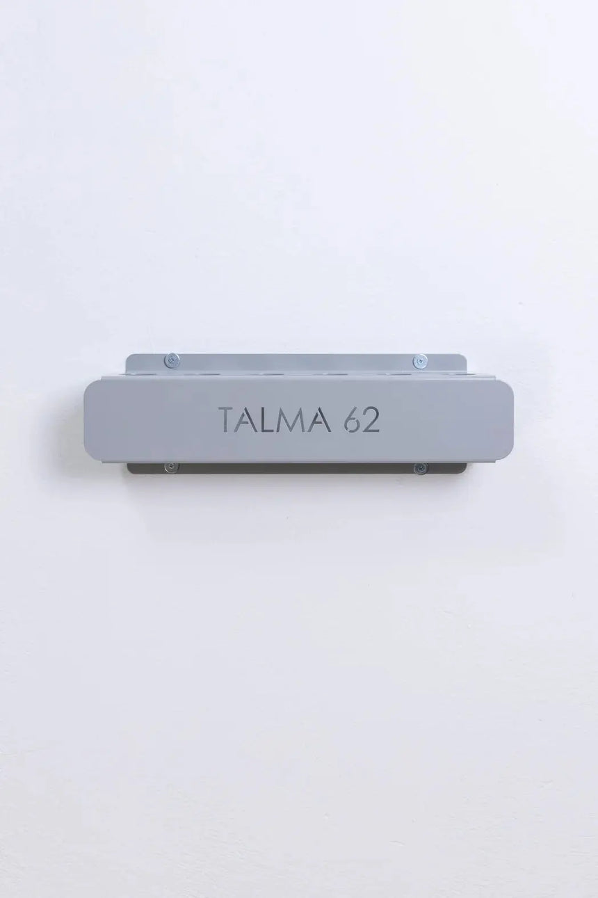 HEGREN Stability Bar Stand mounted on a wall, designed to securely hold the Stability Bar when not in use.