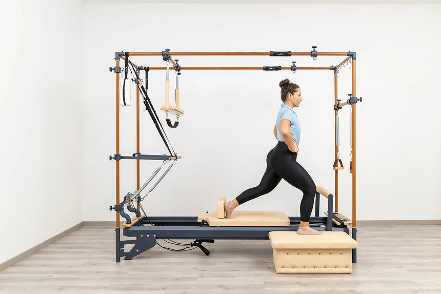 Side view of the HEGREN Cadillac Reformer TALMA 62CR showcasing its steel frame and beige upholstery.