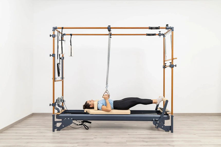 Side view of the HEGREN Cadillac Reformer TALMA 62CR showcasing its steel frame and beige upholstery.