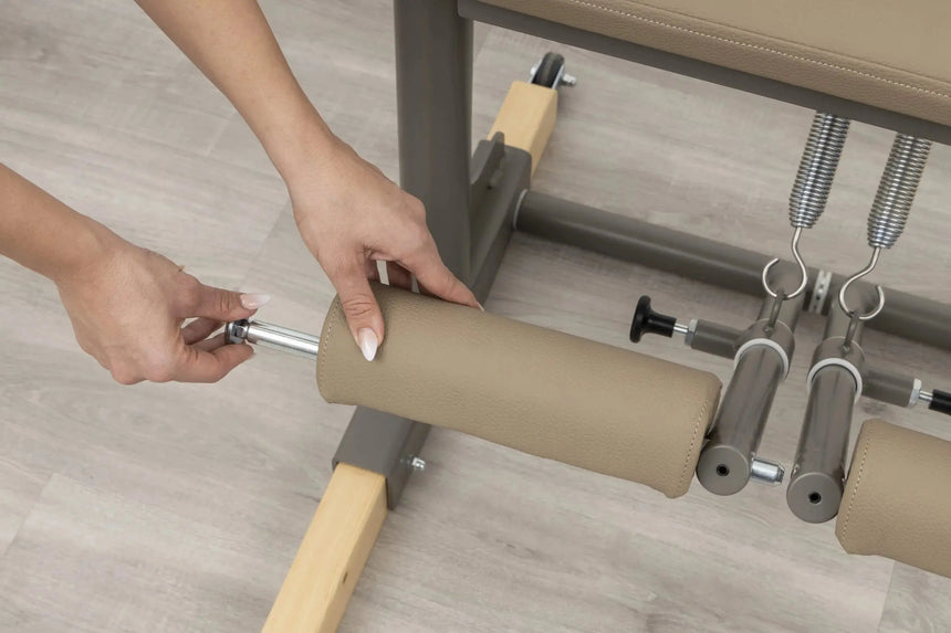 Side view of the HEGREN Pilates Chair TALMA 62CH showcasing its steel frame and beige upholstery.