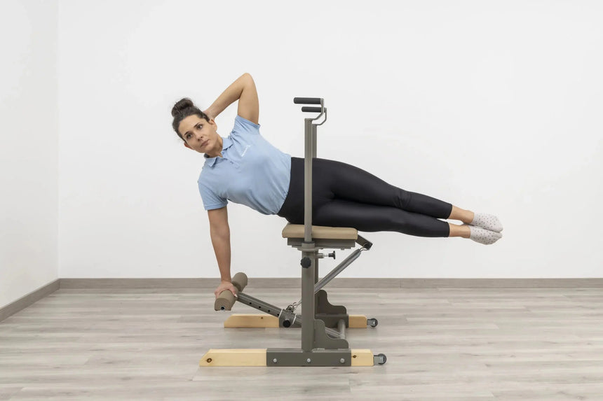 Side view of the HEGREN Pilates Chair TALMA 62CH showcasing its steel frame and beige upholstery.