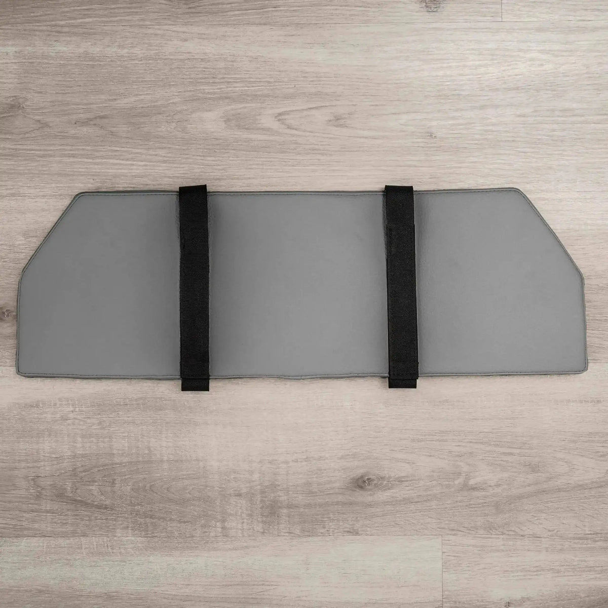 Hegren Platform Pad TALMA Reformer-Auflage, Draufsicht in Grau mit zwei schwarzen Fixiergurten auf Holzboden