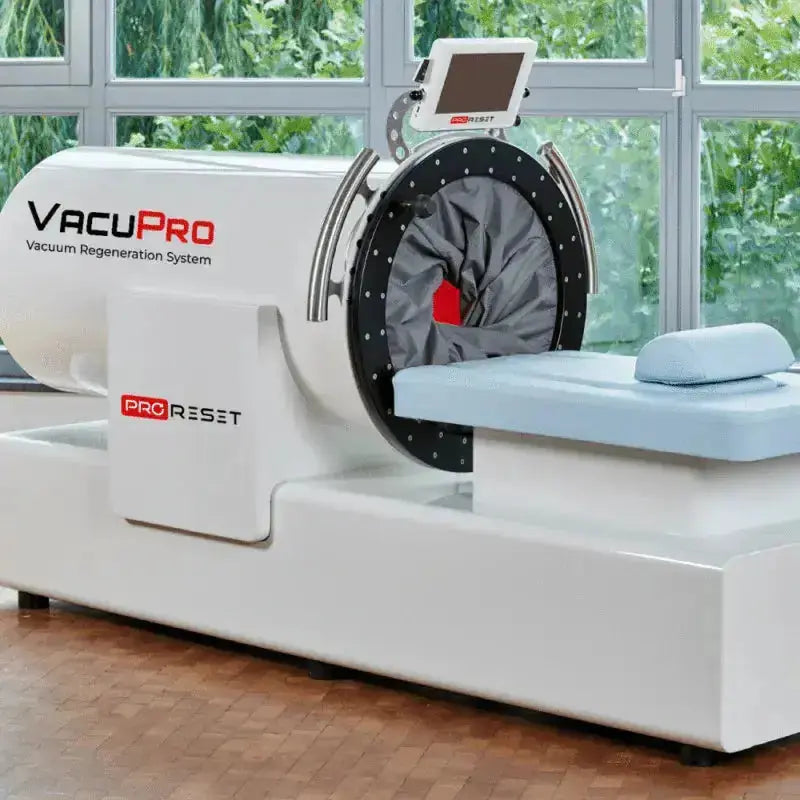 ProReset VacuPro Vakuum-Wellnesssystem – Schrägansicht mit hellblauer Liege vor einer Fensterfront