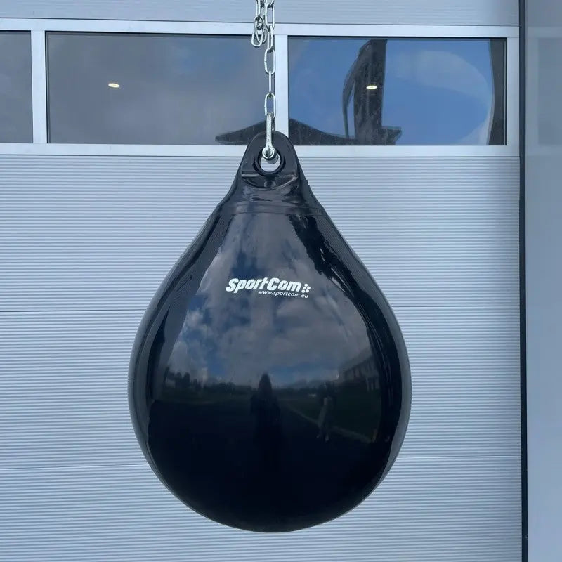 SportCom AquaStrike Wassersandsack Schwarz, hängend an der Kette vor einem Garagentor