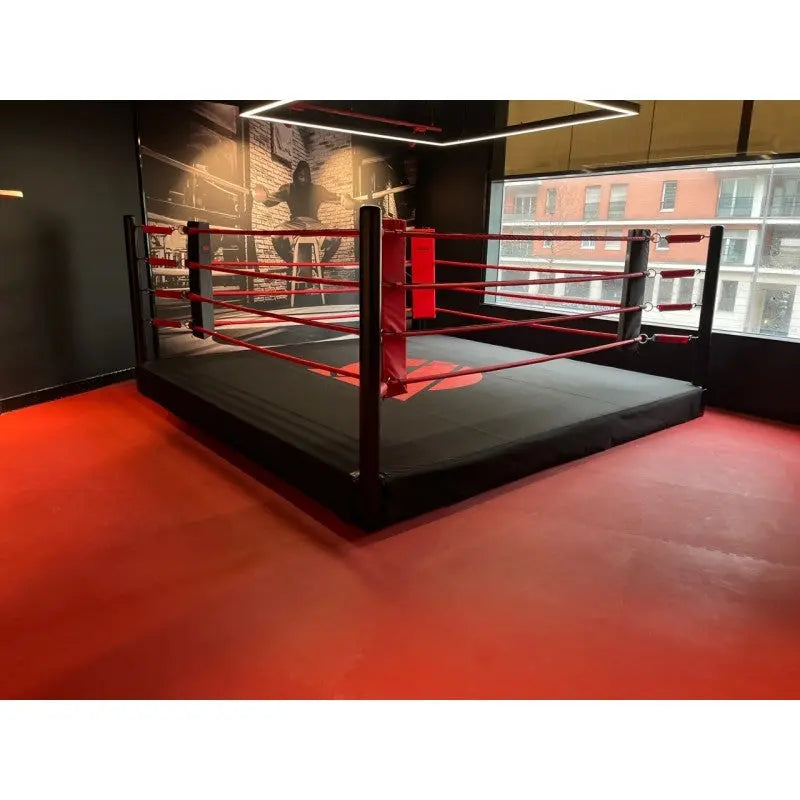 SportCom Boxring-Individualisierung: erhöhter Ring mit roten und schwarzen Seilen auf rotem Studioboden