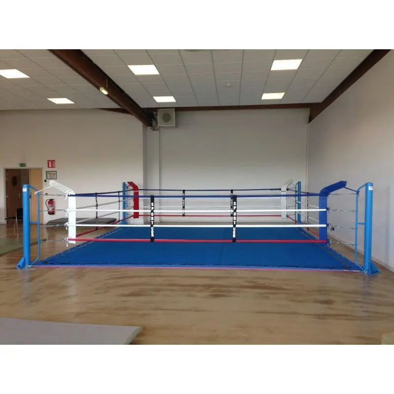 SportCom Ecofix Bodenmontage-Boxring mit Spannseilen, mit blauem Boden in einer weiten Halle