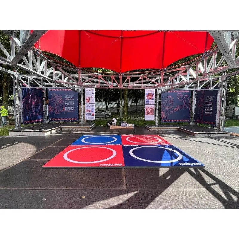 SportCom Flexi-Roll Wrestling Studio-Matte in Rot und Blau unter einem Zeltdach im Freien