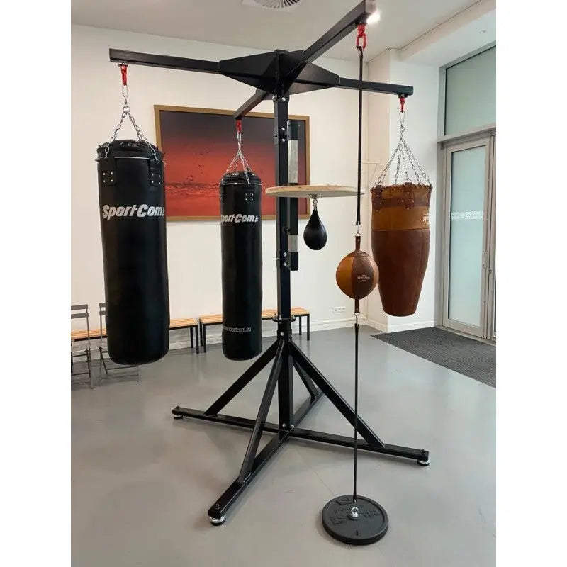 SportCom Freistehende 4-Sack-Station mit Speedball-Plattform, aufgebaut im Studio mit schwarzen und braunem Sack
