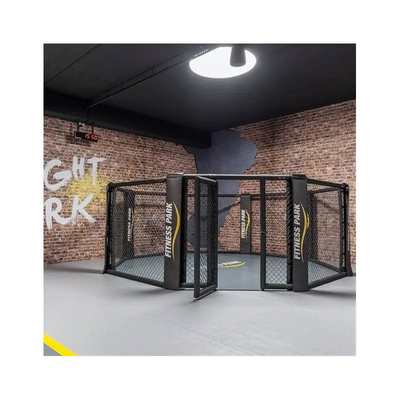 SportCom MMA-Käfig-Individualisierung: kompakter Käfig mit offener Tür vor Backsteinwand mit Wandschrift