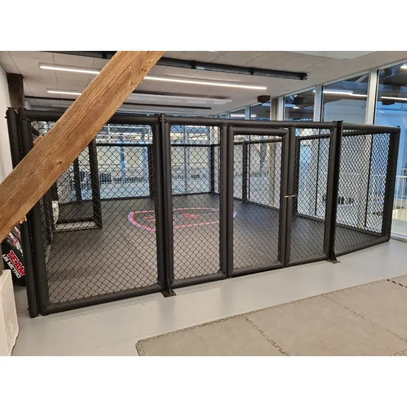 SportCom MMA-Paneel mit Tür als Käfigfläche in heller Halle mit Holzbalken