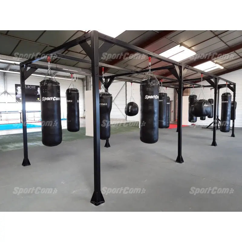 SportCom Modulare Sandsack-Station, in einer Halle mit Sandsäcken und Boxring im Hintergrund