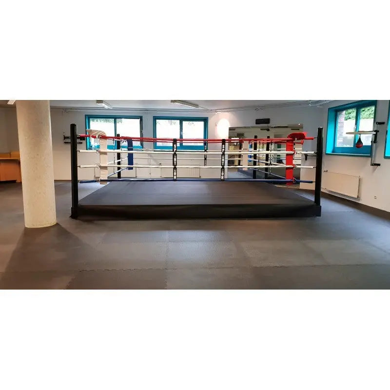 SportCom Pro-Trainingsboxring mit 30 cm Podium, im Trainingsraum mit Säule und Fenstern, Seitenansicht