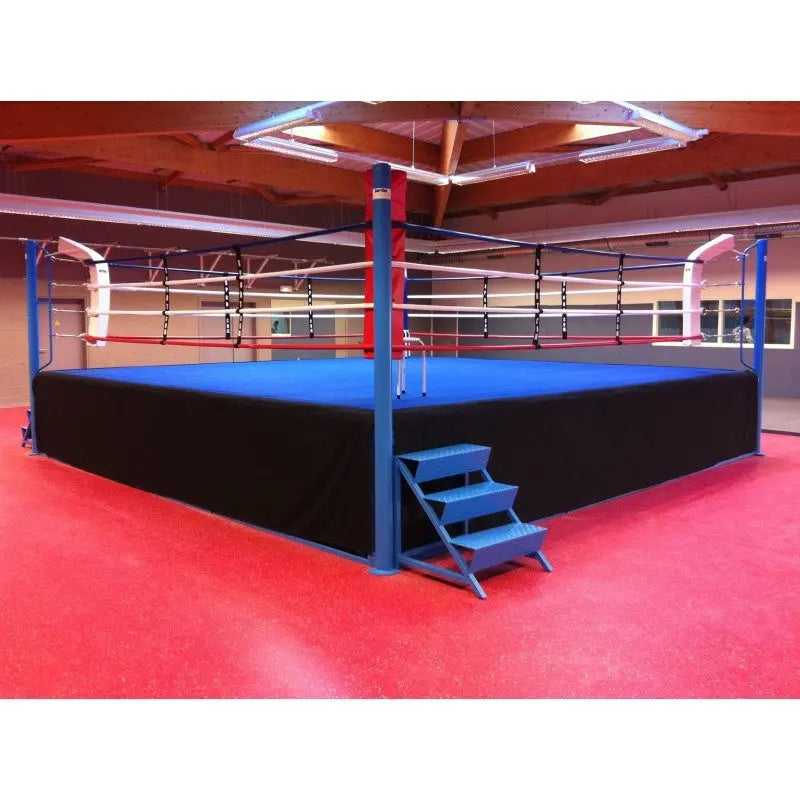 SportCom Pro-Wettkampf-Boxring mit 1 m Podium, mit blauer Fläche auf rotem Hallenboden