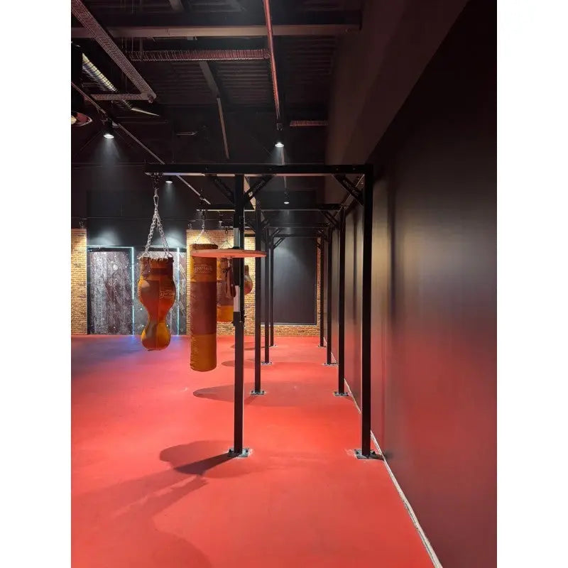 SportCom Proboxe Wandstation für Sandsäcke, mit Ledersäcken in einem langen Gang