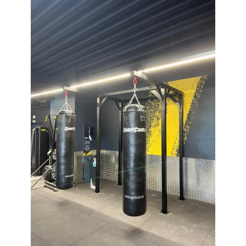 SportCom Proboxe Wandstation für Sandsäcke, im Studio mit gelbem Wandbild, Frontansicht