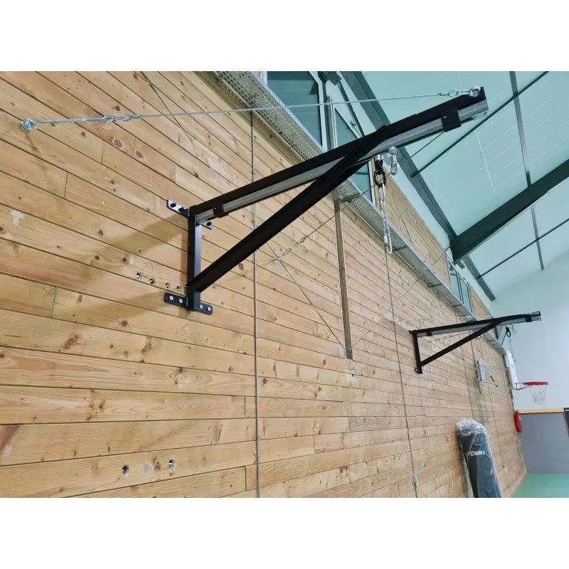 SportCom Sandsack-Wandhalterung mit Schiene und Laufwagen an einer Holzwand in der Sporthalle, Ausleger von vorn