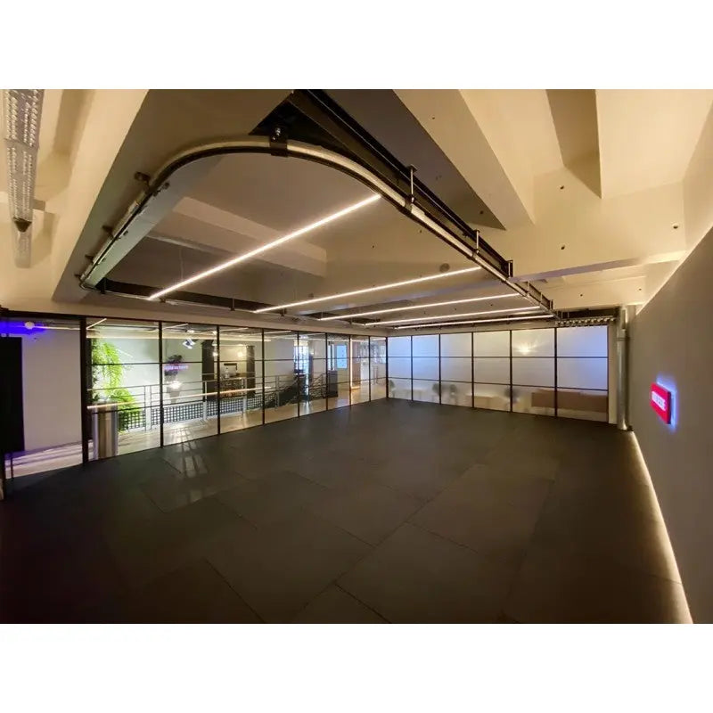 SportCom Überkopf-Förderschiene für Sandsäcke, an der Decke eines leeren Raums mit Fensterfront