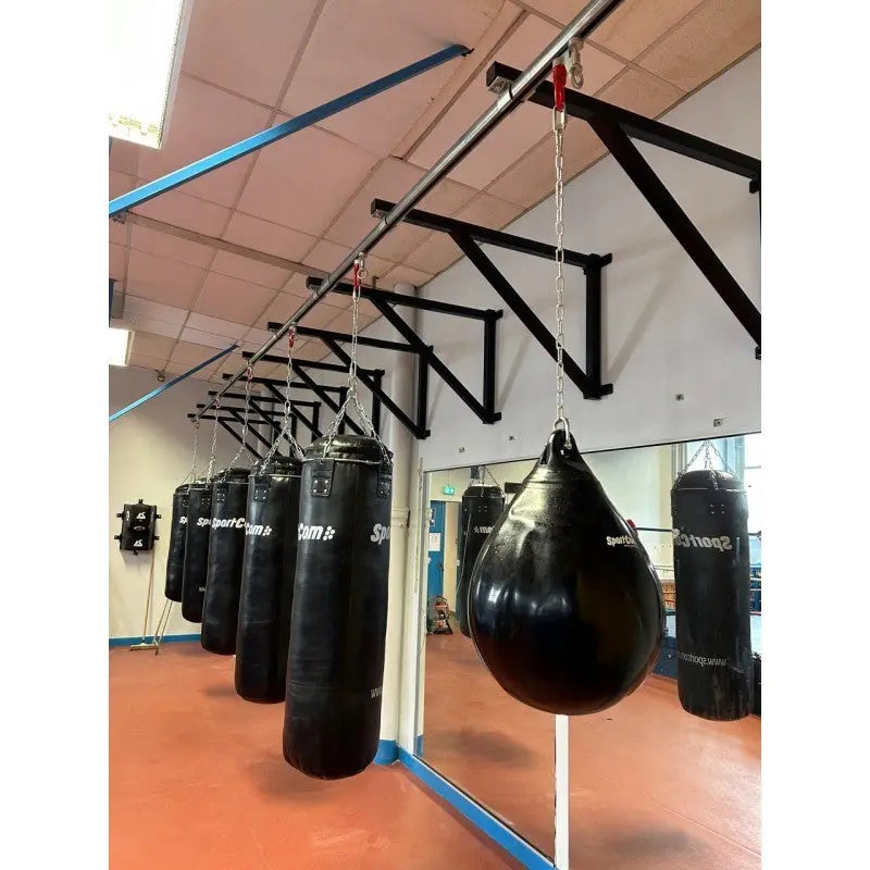 SportCom Wandmontierte Schiene für Sandsäcke, in einem Gym mit Spiegel und Maisbirne