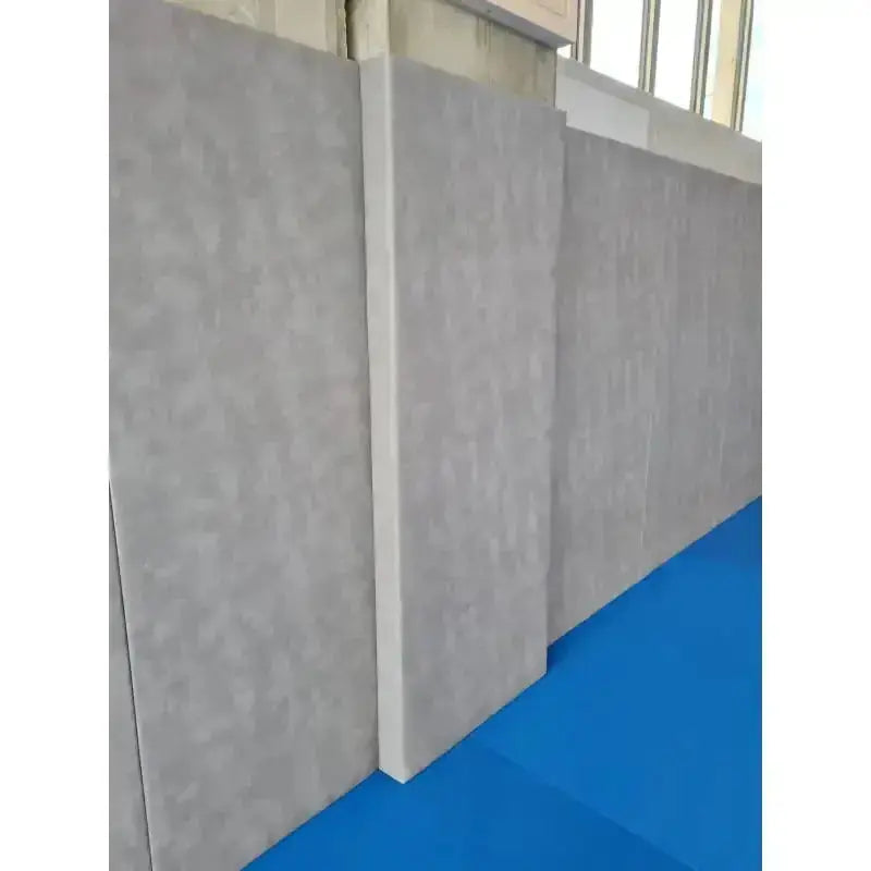 SportCom Wandpolster Standard SC-16211, graue Platten an der Hallenwand über blauer Matte, Schrägansicht