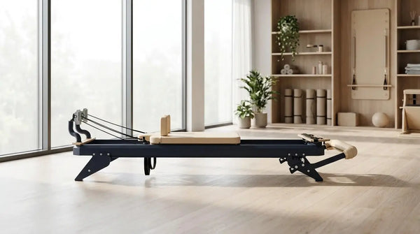 Hegren Pilates-Reformer mit Stahlrahmen auf einem hellen Holz-Sportboden in einem modernen Studio