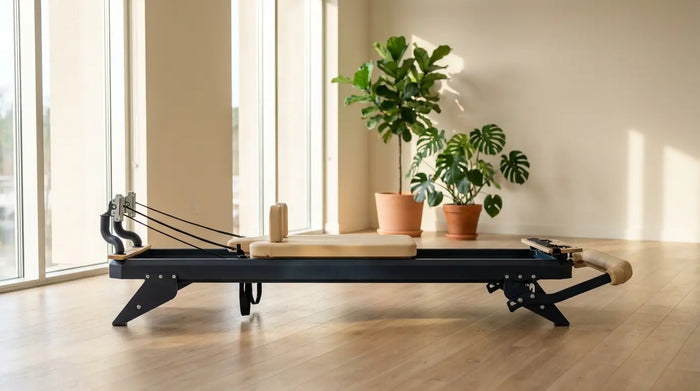 Premium Pilates Reformer mit Stahlrahmen in einem hellen modernen Studio mit Holzboden und großen Fenstern