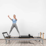  Side view of the HEGREN Pilates Reformer LEGATO 22 showcasing its steel frame and black upholstery.