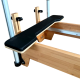 Wooden exercise bench with black seat pad on a white background