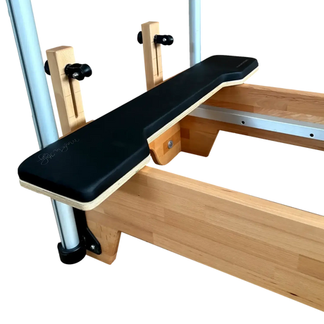 Wooden exercise bench with black seat pad on a white background