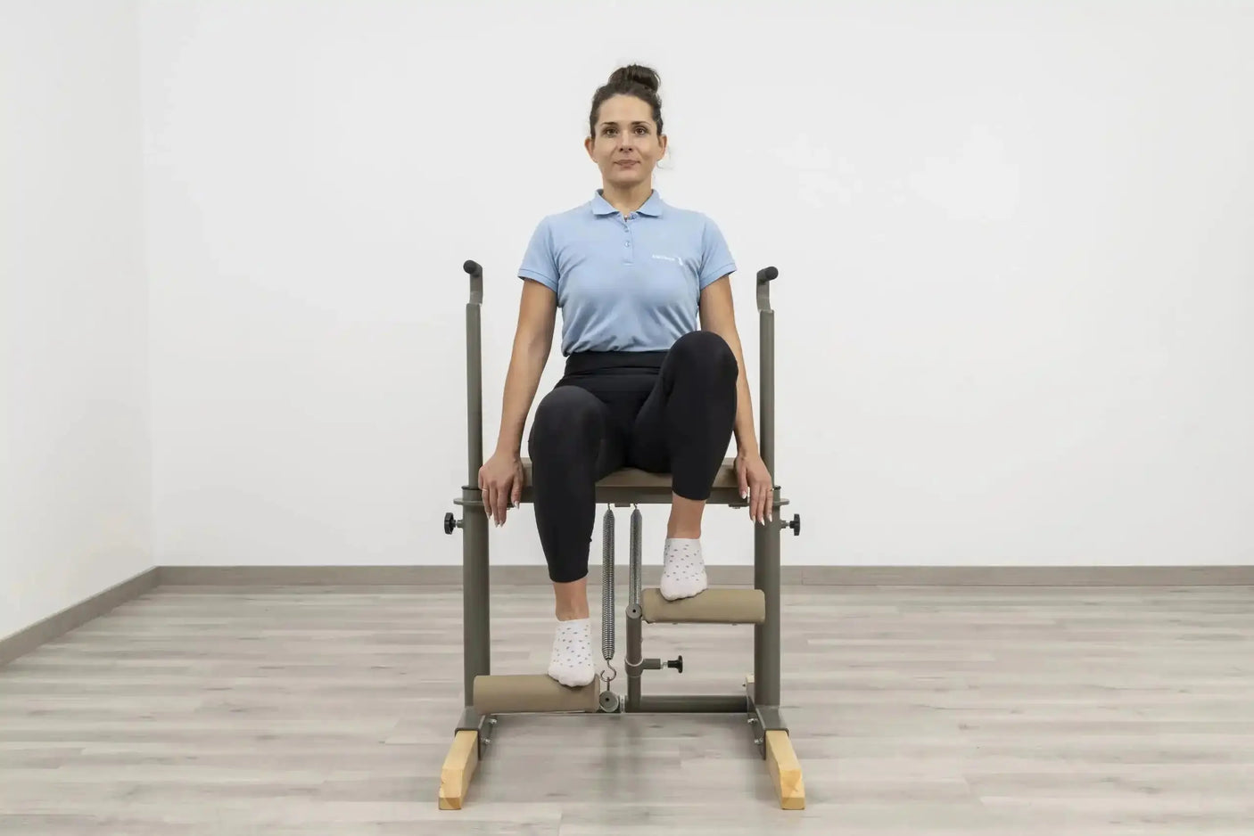  Side view of the HEGREN Pilates Chair TALMA 62CH showcasing its steel frame and beige upholstery.