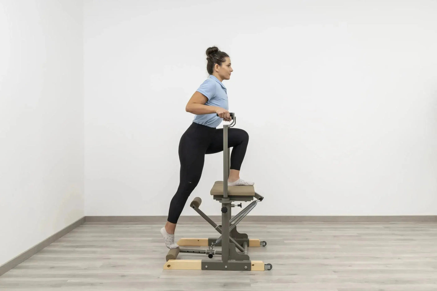 Side view of the HEGREN Pilates Chair TALMA 62CH showcasing its steel frame and beige upholstery.