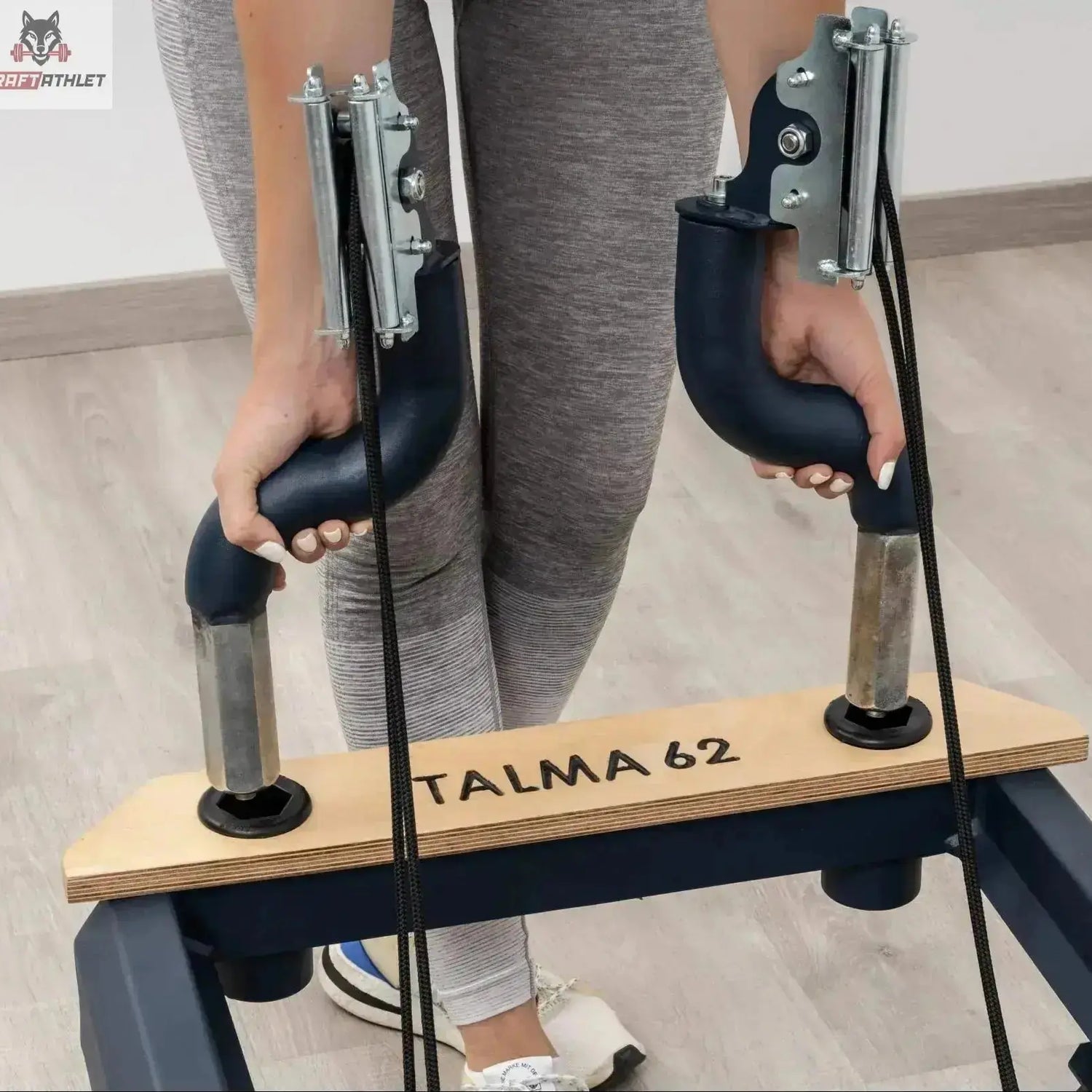 Side view of the HEGREN TALMA 62 Pilates Reformer showcasing its steel frame and beige upholstery.