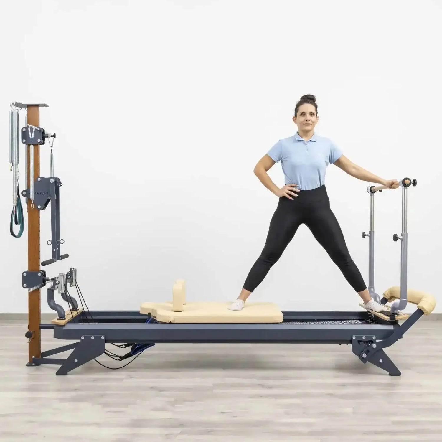 HEGREN Stability Bar attached to a Pilates Reformer, enabling safe execution of standing exercises like side and front splits.