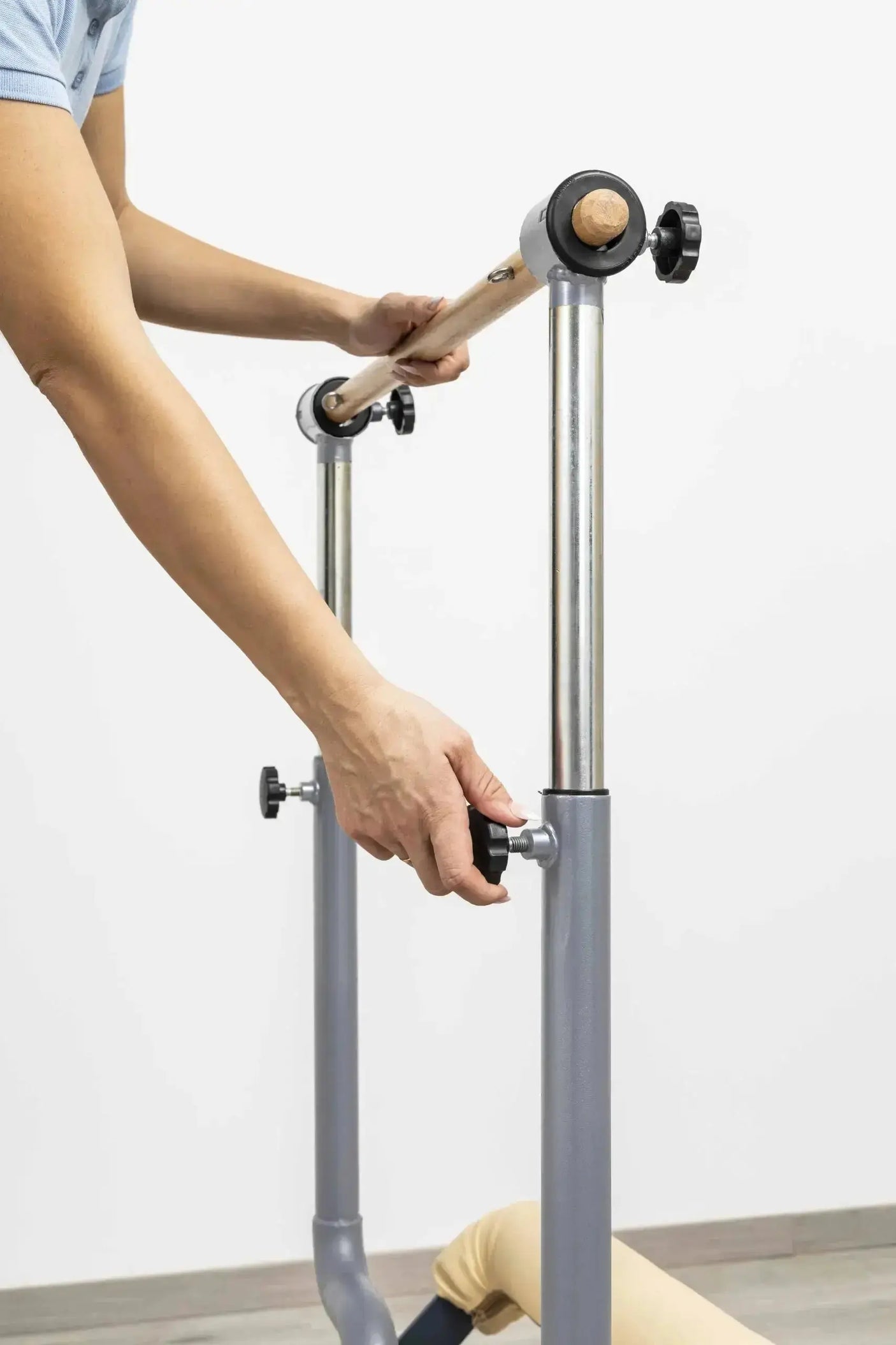 HEGREN Stability Bar attached to a Pilates Reformer, enabling safe execution of standing exercises like side and front splits.