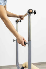 HEGREN Stability Bar attached to a Pilates Reformer, enabling safe execution of standing exercises like side and front splits.