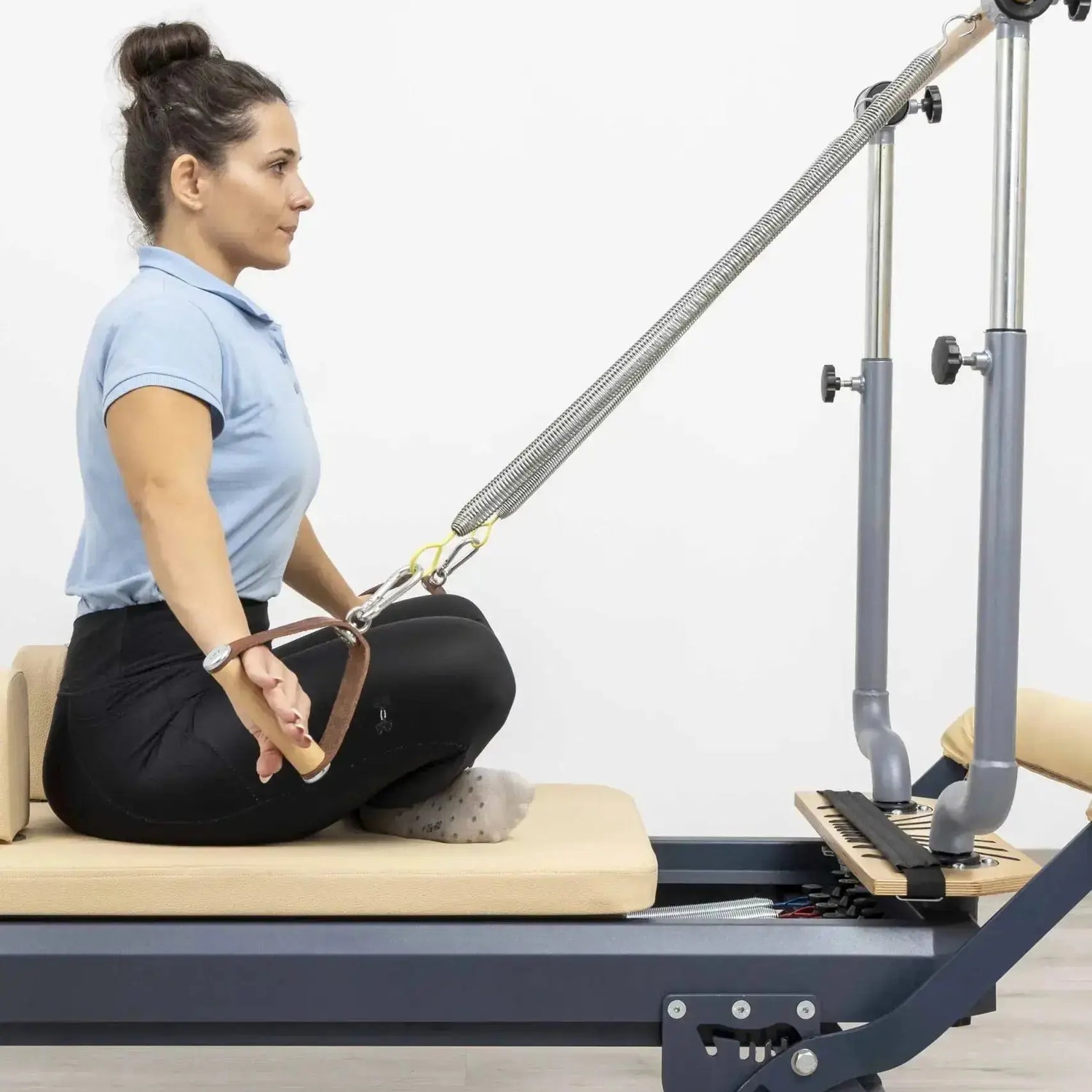 HEGREN Stability Bar attached to a Pilates Reformer, enabling safe execution of standing exercises like side and front splits.