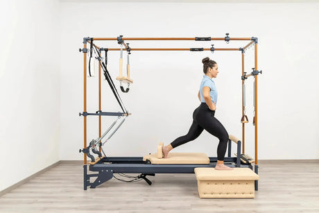 Side view of the HEGREN Cadillac Reformer TALMA 62CR showcasing its steel frame and beige upholstery.