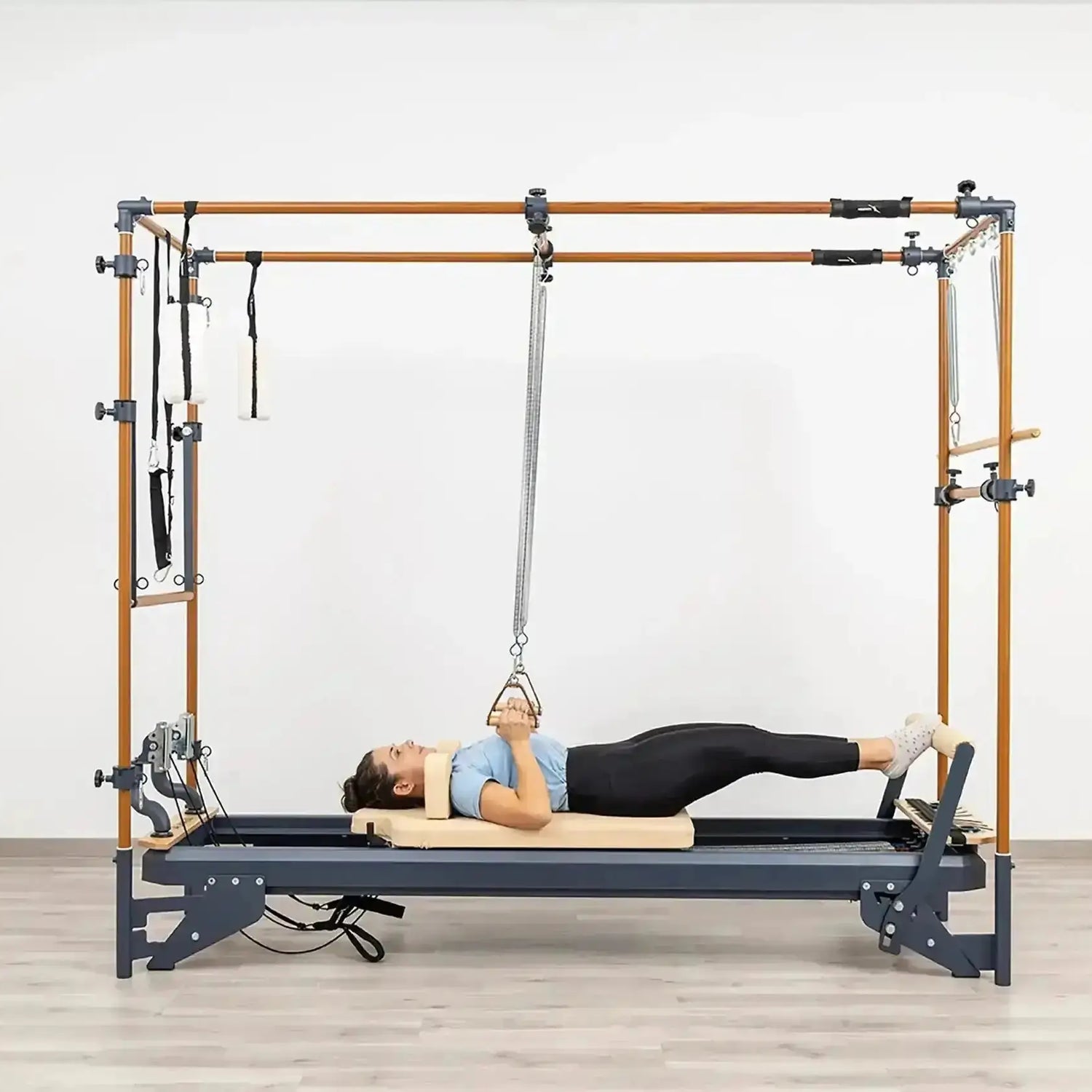 Side view of the HEGREN Cadillac Reformer TALMA 62CR showcasing its steel frame and beige upholstery.